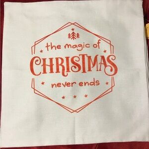 NWT cream throw pillow cover with “the magic of Christmas never ends” in red